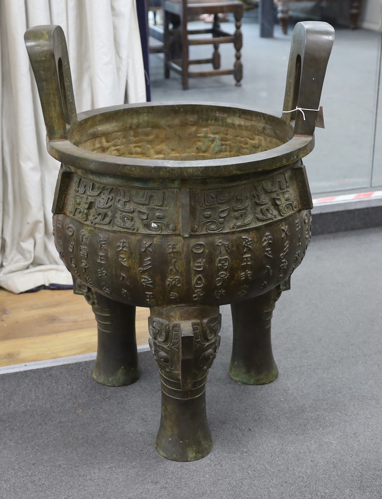 A massive Chinese bronze tripod vessel, ding, 85cm tall